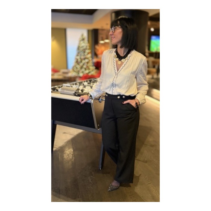 Cette blouse écru et noir allie élégance et confort grâce à sa matière fluide et légère. La broderie fine noire sur la boutonniè